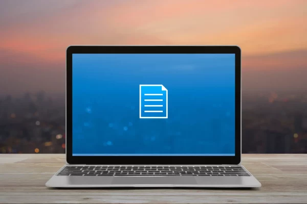 Document flat icon with modern laptop computer on wooden table over blur of cityscape on warm light sundown, Business communication online concept Nouvelle fonctionnalité Amelkis W365
