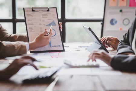 Financial analysts analyze business financial reports on digital partenariat entre OneStream et Xignux